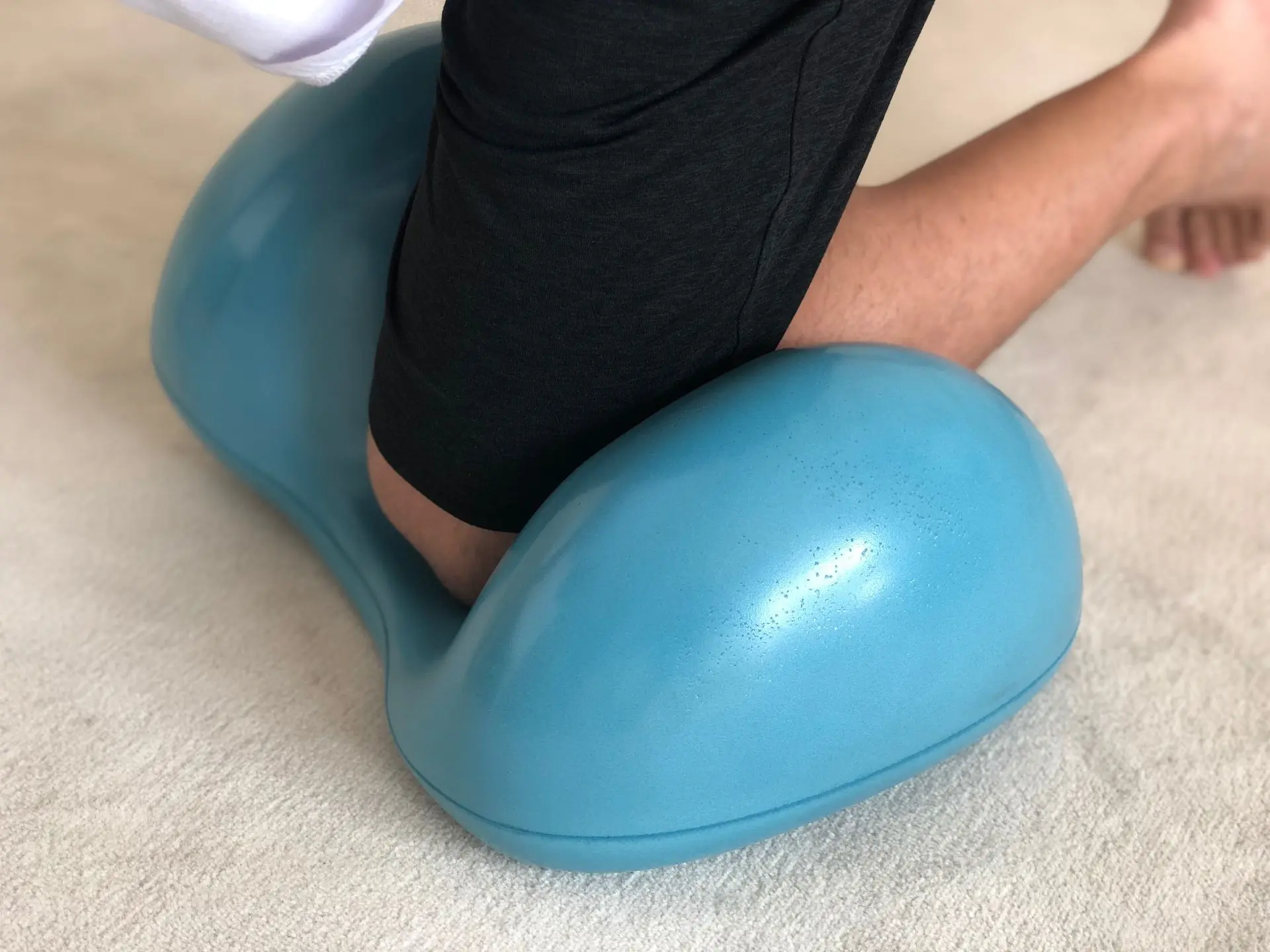 Man kneeling on blue Air8 on the floor for knee exercise
