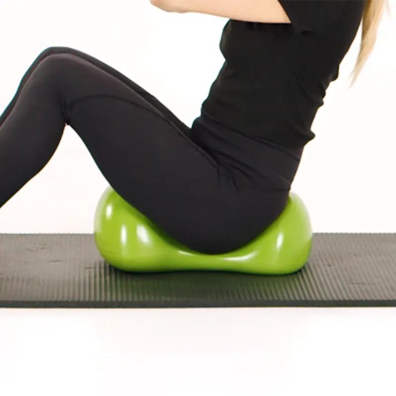 Fitness girl sitting on a green Air8 cushion in base position during core training