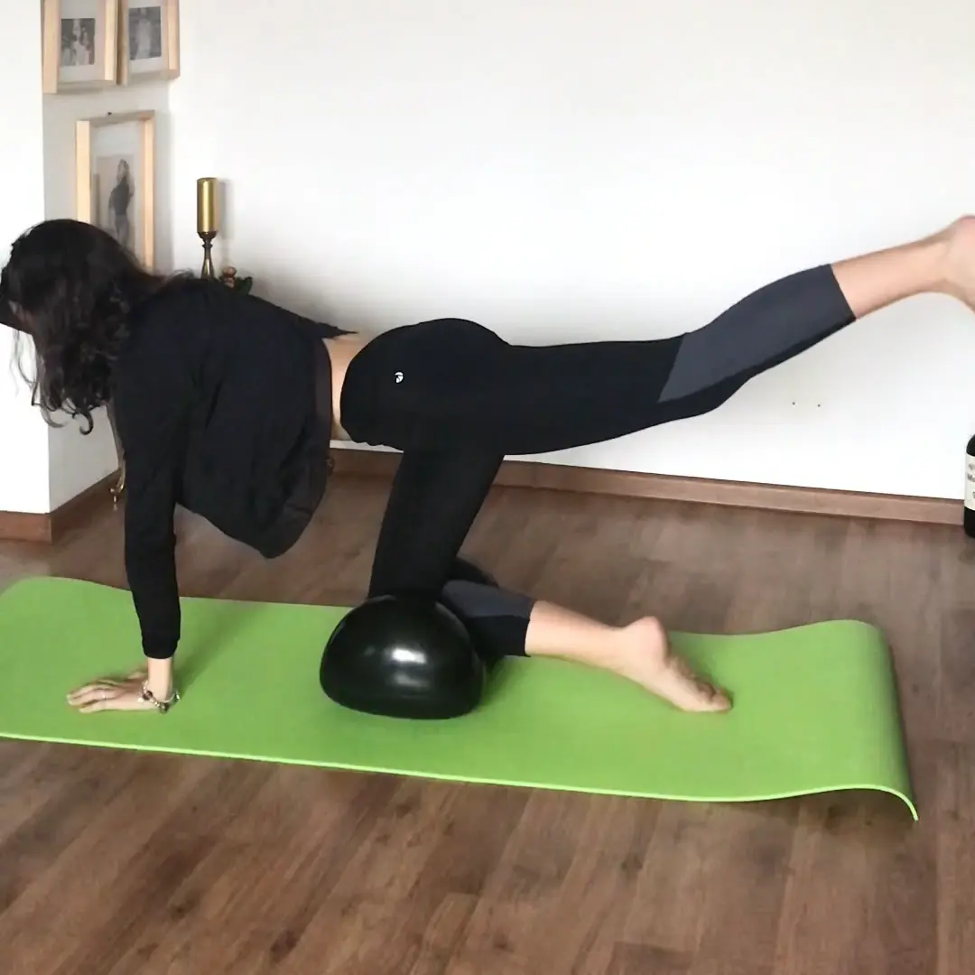 Woman doing leg exercises on green mat at home with the Air8